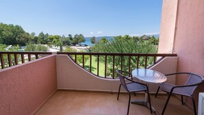 A balcony with a curved railing, a small round table, and two chairs. - Galaxy Hotel (Kefalonia)