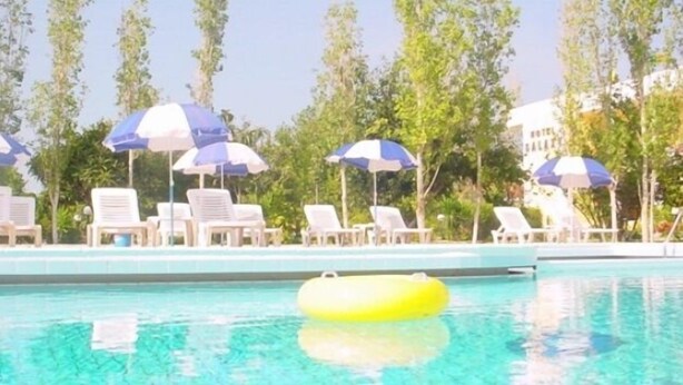 A swimming pool with lounge chairs and umbrellas. - Galaxy Hotel (Kefalonia)
