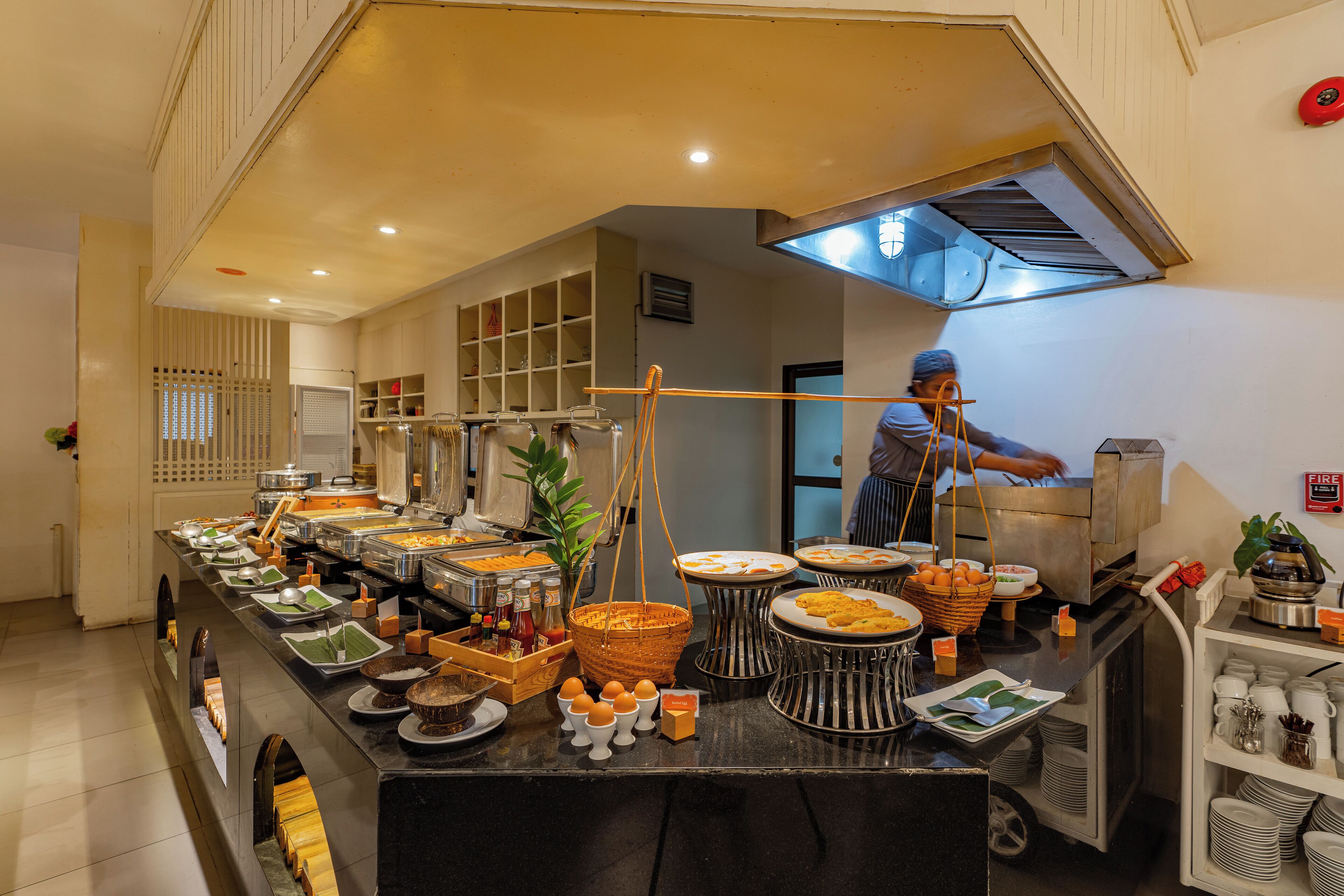 Ein Buffet mit verschiedenen Speisen und einer Person, die etwas zubereitet.