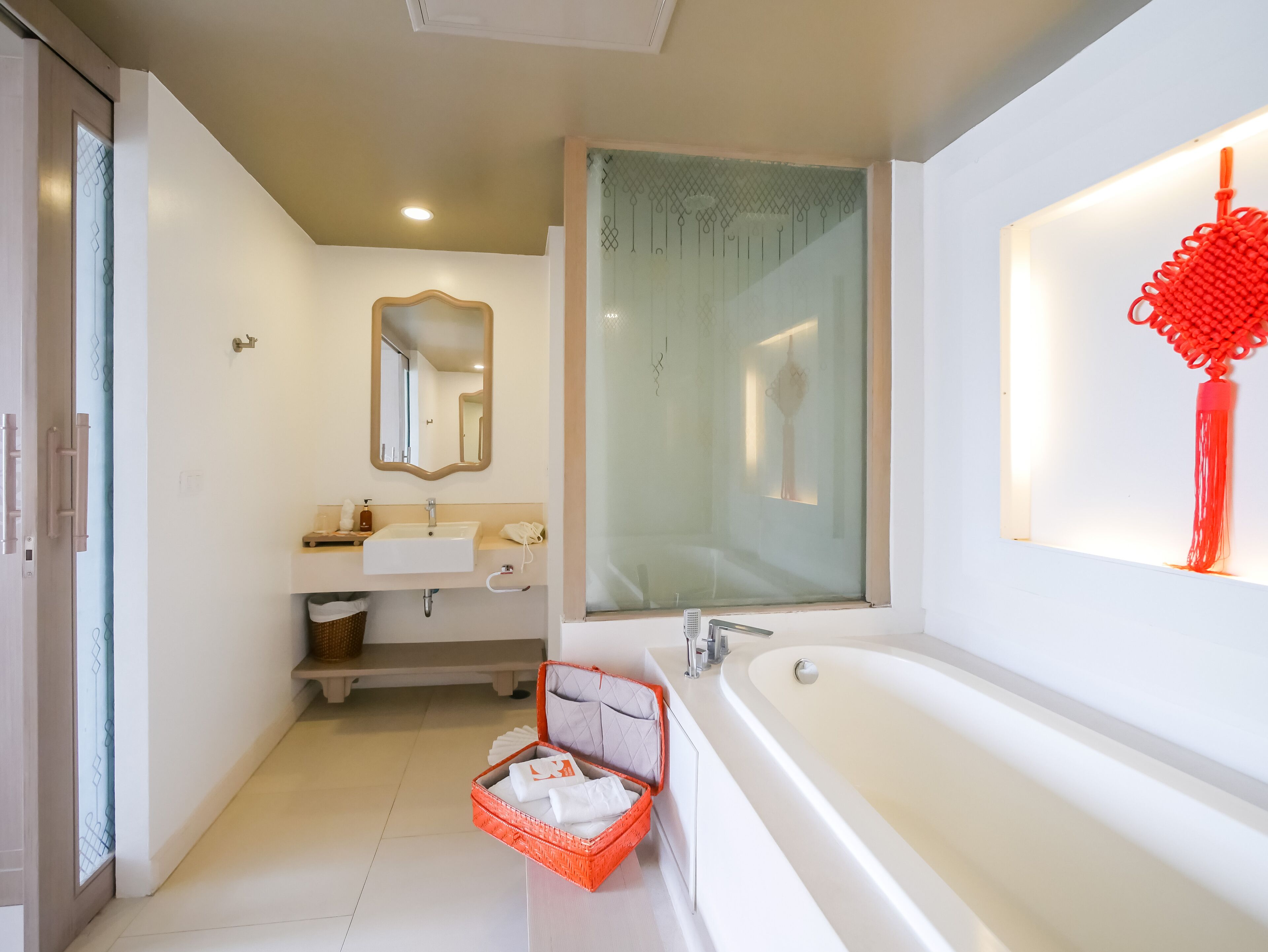 Une salle de bain moderne avec une grande baignoire, un lavabo avec un miroir au-dessus et un espace douche.
