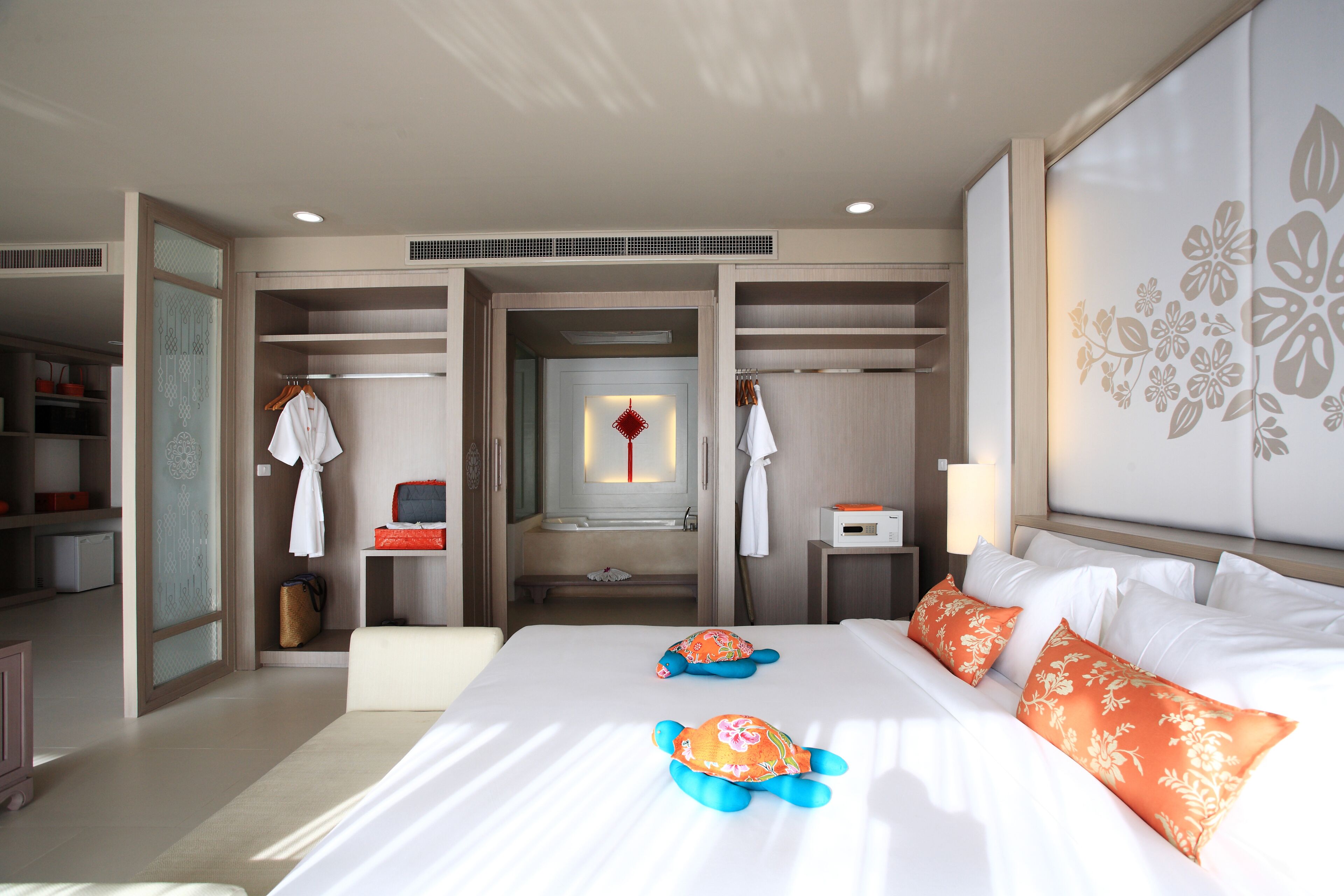 A hotel room with a large bed, a wardrobe, a bathroom, and a view of the hallway.