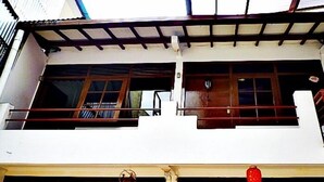 A two-story building with a balcony on the upper floor and a red lantern hanging on the lower floor. - De Sun Pasteur Guest House by HouseinBandung (Bandung)