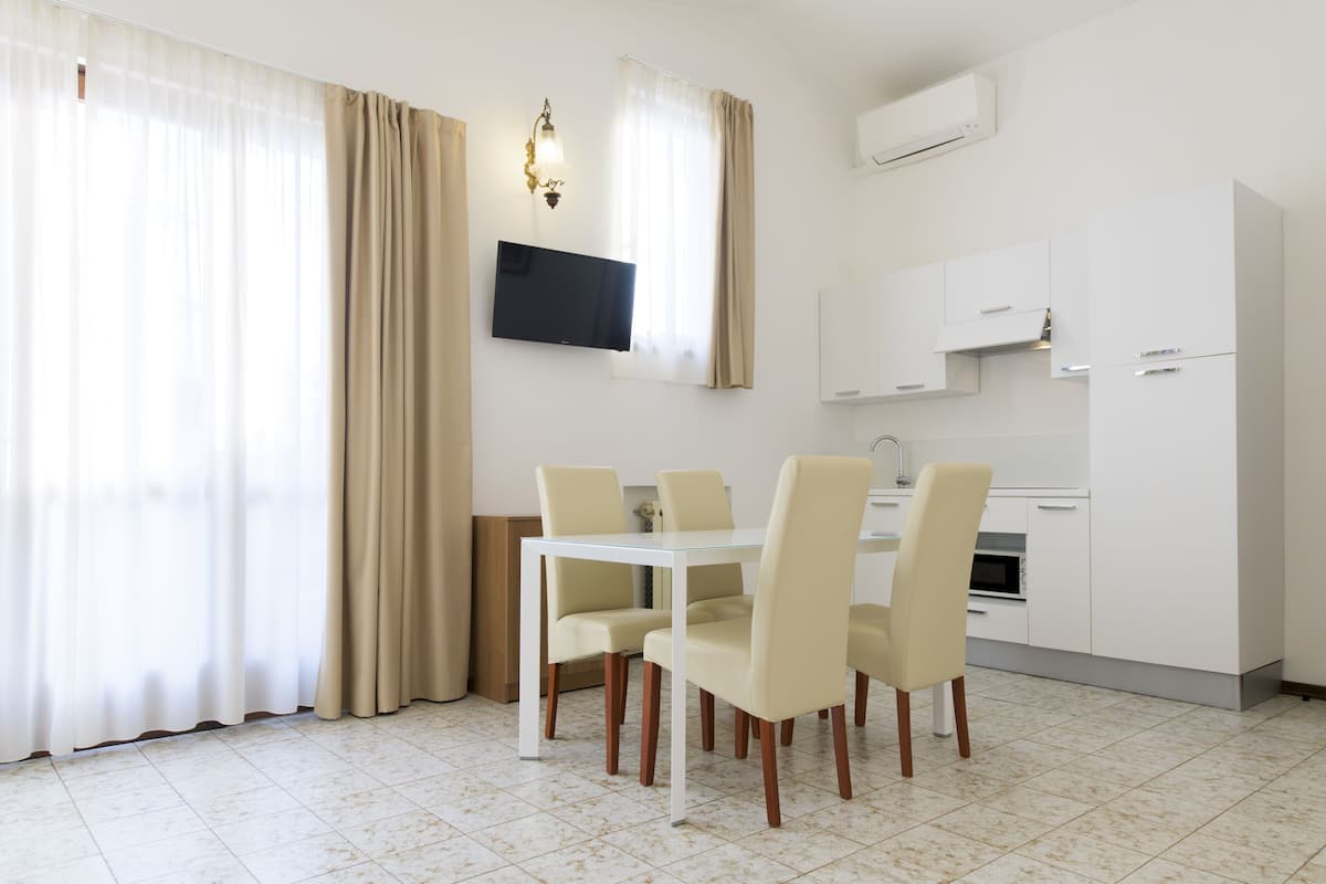 A modern kitchen with white cabinets, a built-in oven, and a microwave.