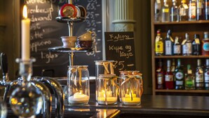 A bar area with a candle, glasses, and a chalkboard menu. - Fuglsang Herregaard Hotel (Toreby)