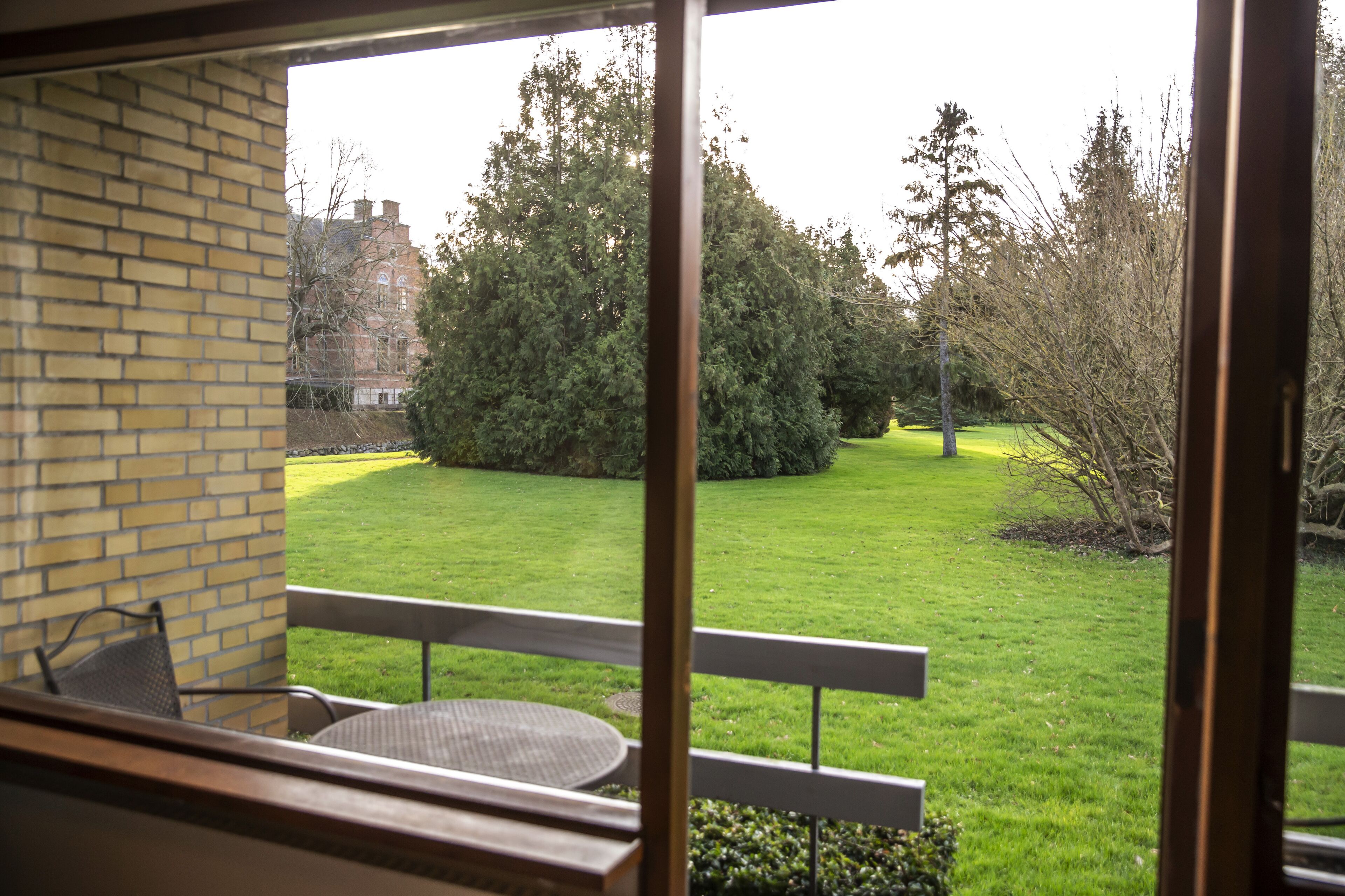 A view from a balcony with a brick wall and a table.
