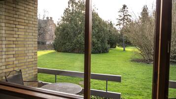 A view from a balcony with a brick wall and a table.