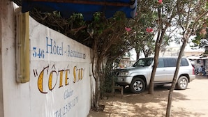A white wall with a sign for "Hôtel Restaurant 546" and "Côte Sud Glacier" along with a telephone number. - Hotel Restaurant Coté Sud (Lomé)