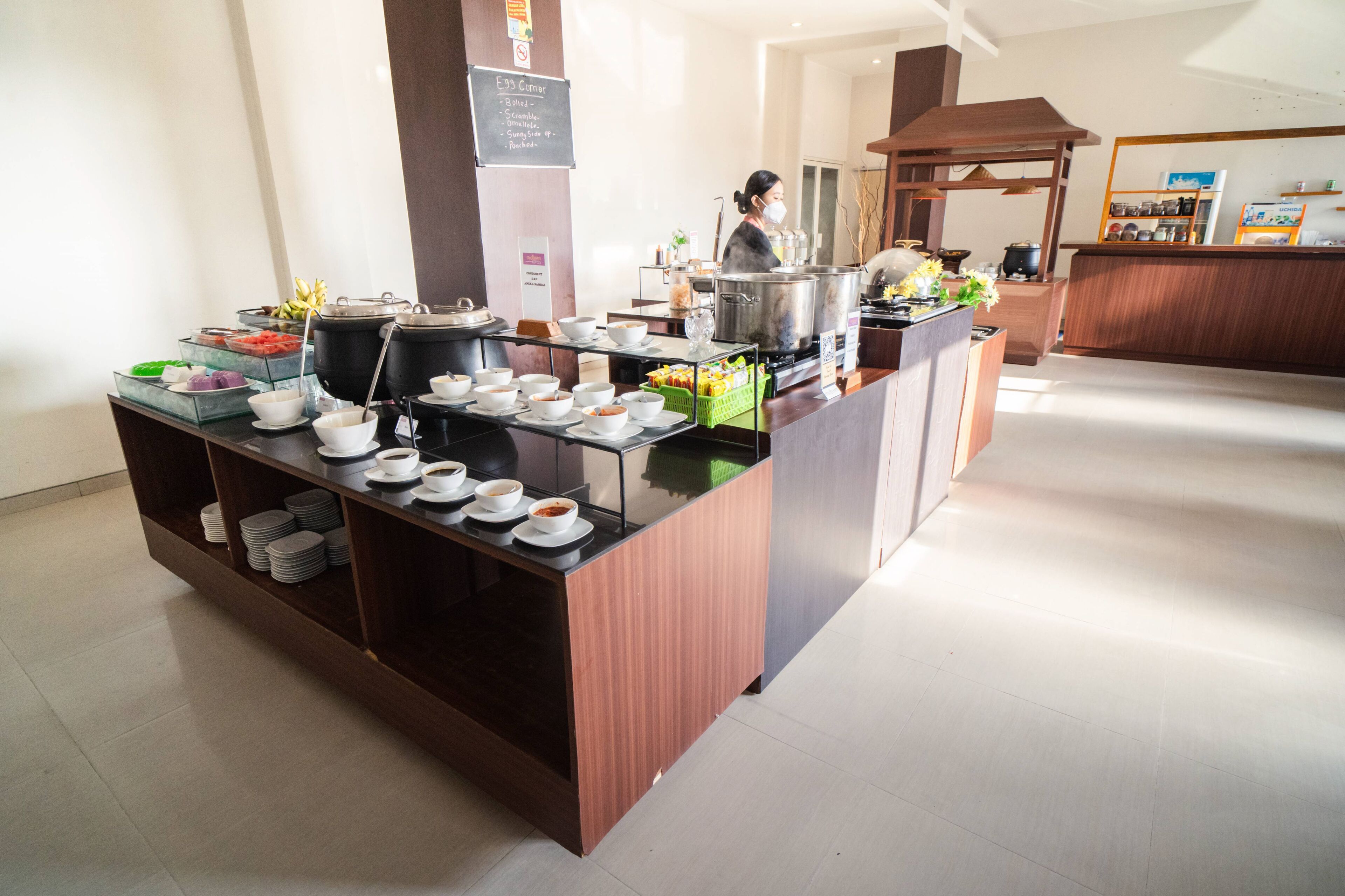 A buffet setup with various food items and a person in the background.