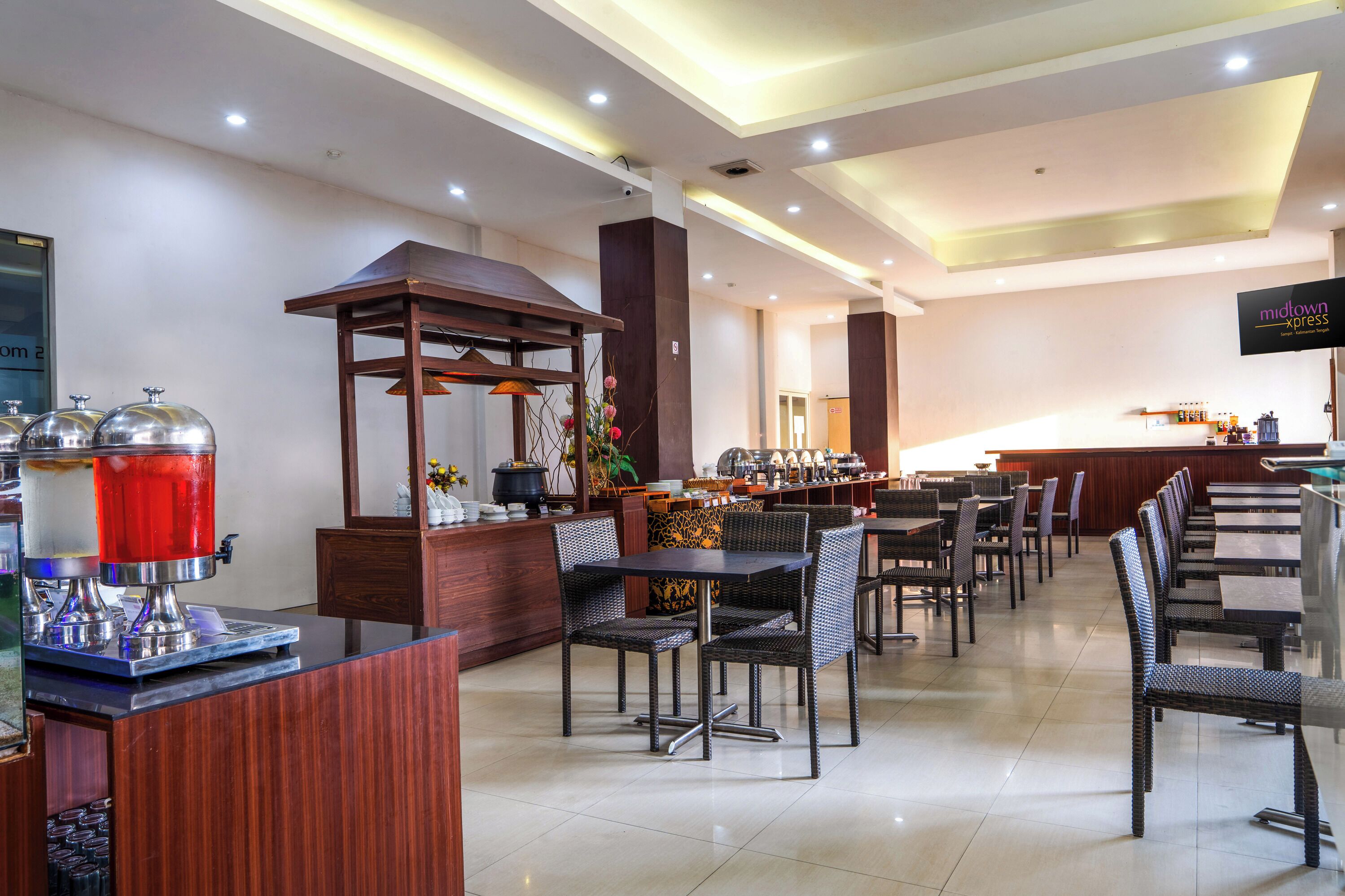 A hotel lobby with a reception desk, seating area, and a buffet.