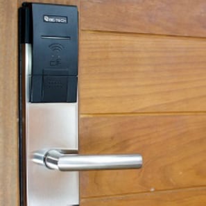 A modern door with a keycard reader and a metallic handle.
