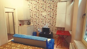 A small room with a bed, a desk, a chair, a radiator, and a window. - Golden Galata Hotel (Istanbul)