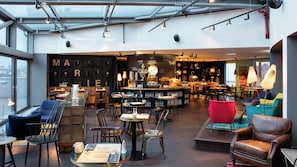 A café with tables, chairs, and a bar area. - Ruby Marie Hotel Vienna by IHG (Vienna)