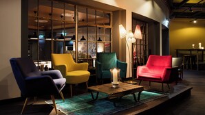 Een moderne zithoek met een houten salontafel, diverse stoelen en een groot raam met uitzicht op het interieur.