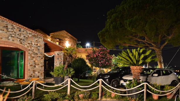 A stone building with a pool, surrounded by greenery and a rope barrier. - Villa Quiete (Spadafora)