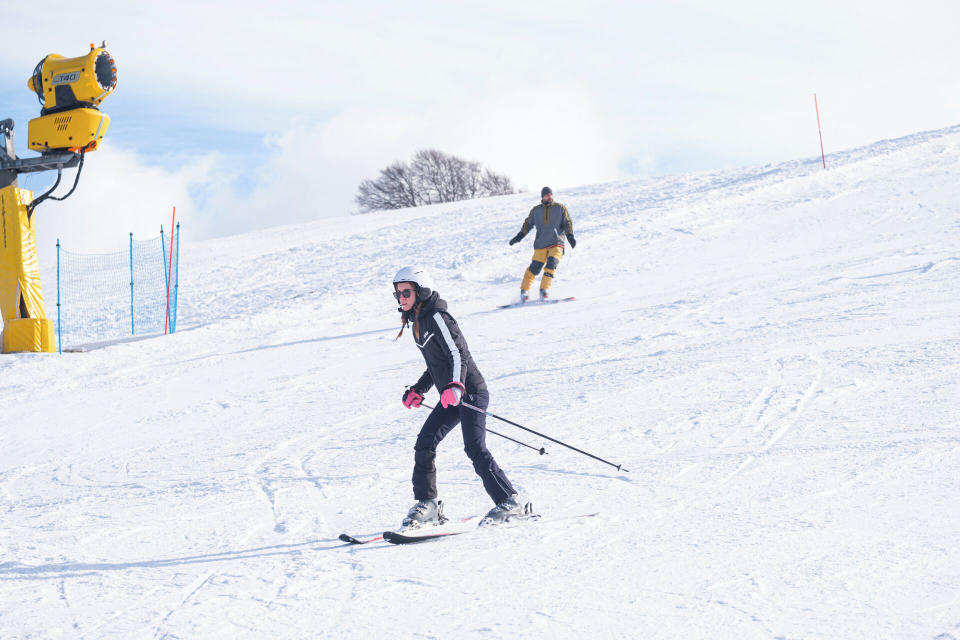 A snowy ski slope with skiers.