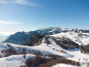 A panoramic view of a snow-covered mountainous landscape with clear skies. - Family Hotel Polsa (Brentonico)
