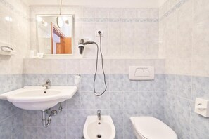 A bathroom with two sinks, a bidet, and a toilet. - Family Hotel Polsa (Brentonico)