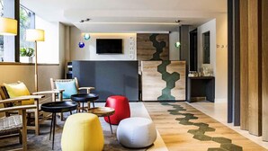 Un intérieur moderne avec des sièges, un comptoir d’accueil et un mur décoratif en bois.