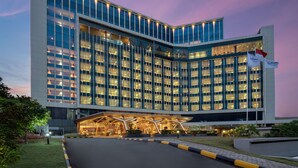 Un hotel moderno con un llamativo letrero de Radisson, amplias ventanas de vidrio y una entrada bien iluminada.