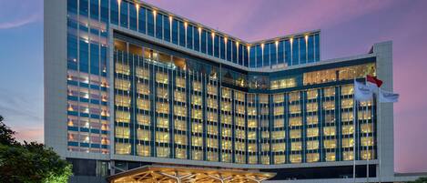 A modern hotel with a prominent Radisson sign, large glass windows, and a well-lit entrance.