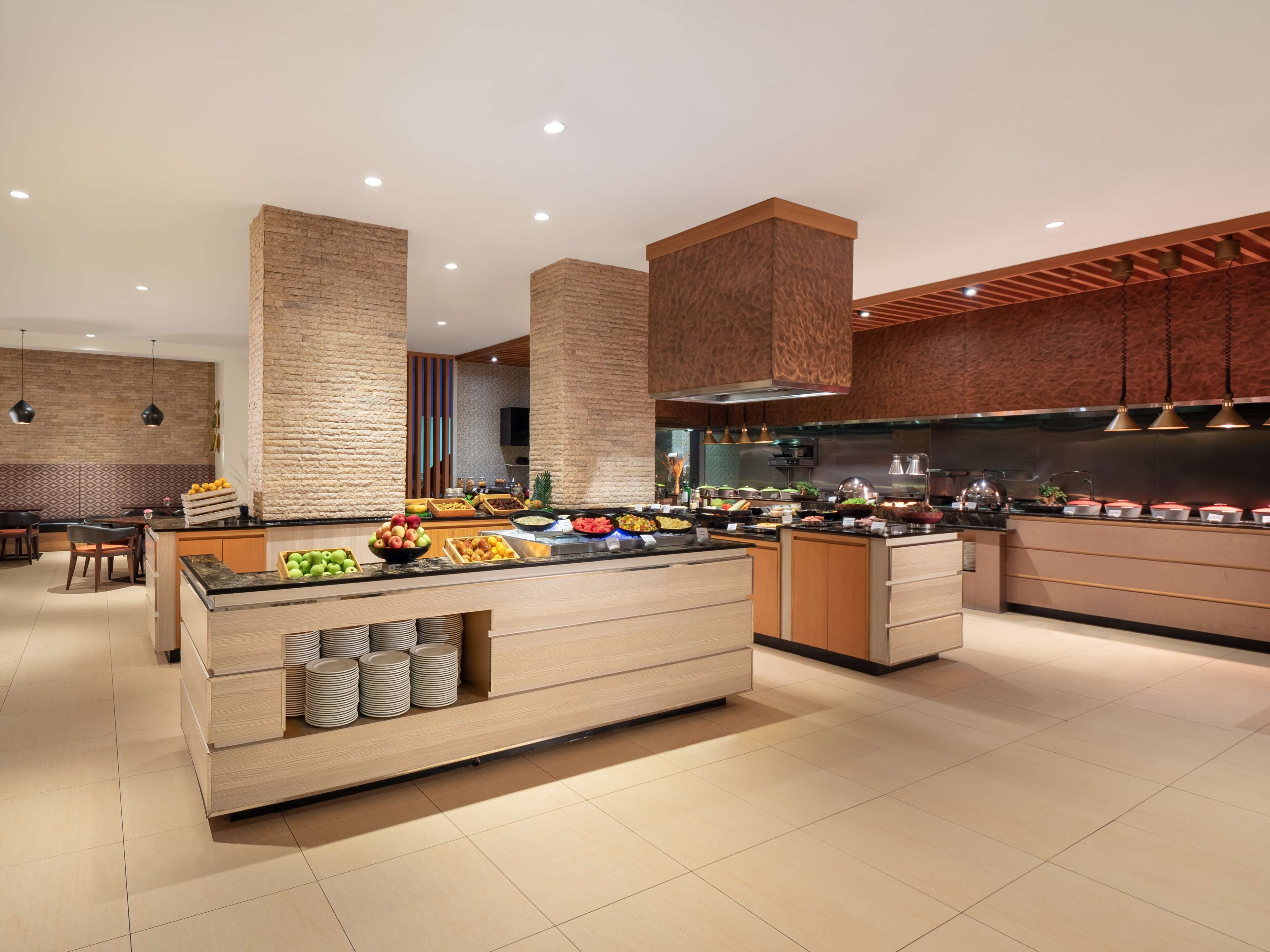 Una cocina moderna con una isla central, armarios de madera y una pared decorada con ladrillos.