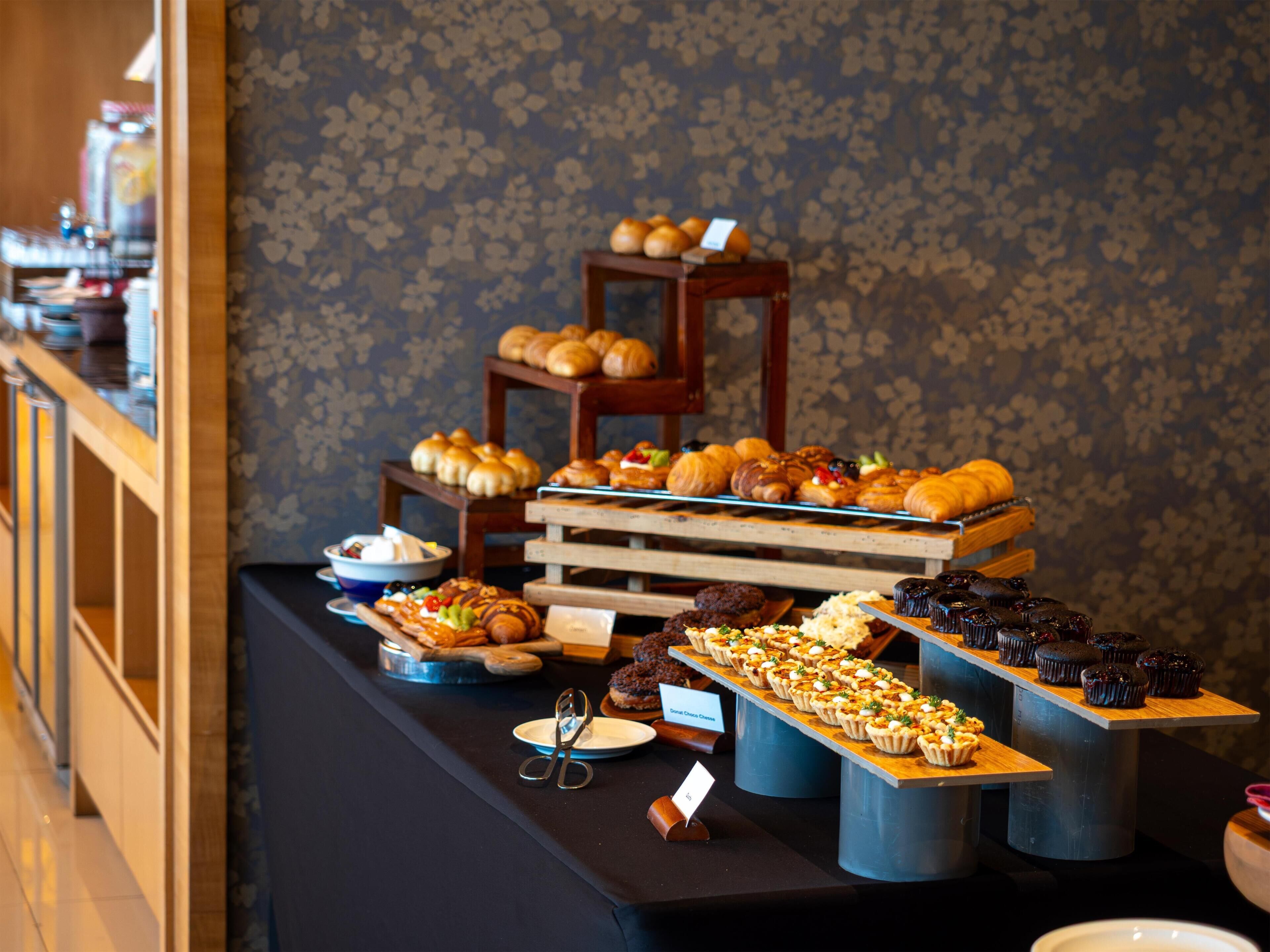Un buffet proposant une variété de produits de boulangerie et de pâtisserie.
