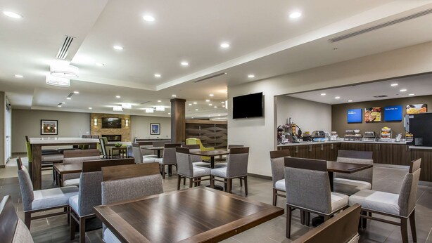A modern restaurant with multiple dining areas, including booths and tables, and a counter with food displays. - Comfort Inn & Suites Snyder (Snyder)