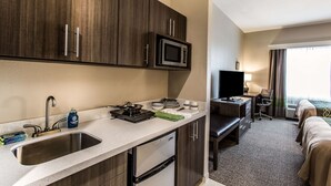 A compact hotel kitchen with a microwave, sink, and a small dining area. - Comfort Inn & Suites Snyder (Snyder)