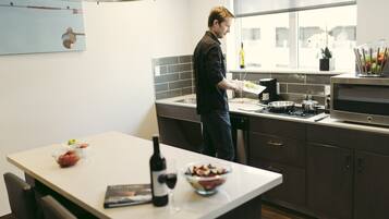 Een moderne keuken met een groot eiland, een raam met uitzicht en diverse keukenapparaten.