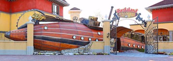 Un'imponente e decorata cancellata con un cartello che indica 'Gandaland Adventure Hotel'.