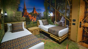 Een kamer met twee bedden, een klein tafeltje en een muurschildering van een tempel.