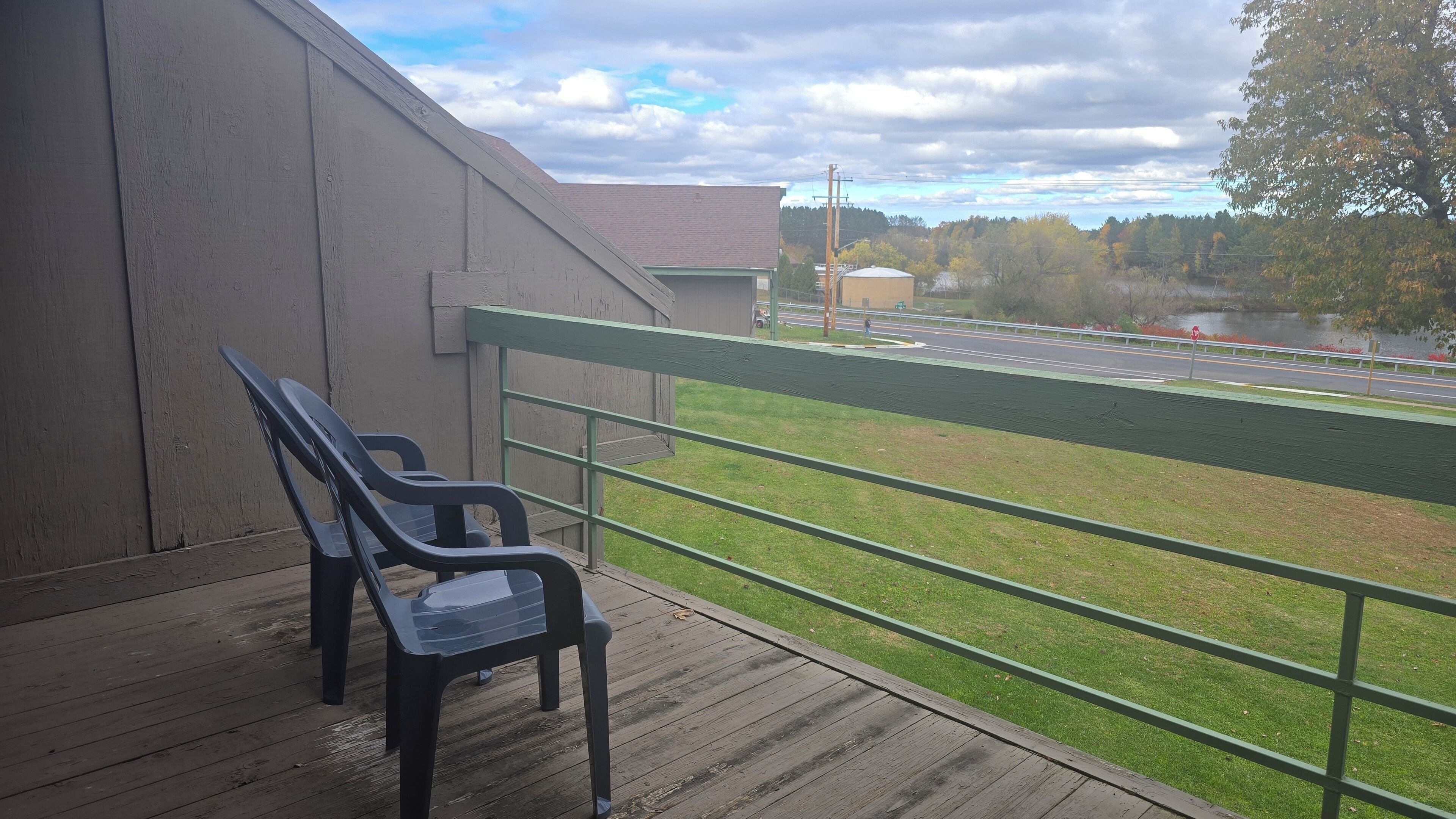 A balcony with a view of a road and a lake.