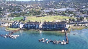 Un hotel frente al agua con varias edificaciones, barcos amarrados y un puerto deportivo.