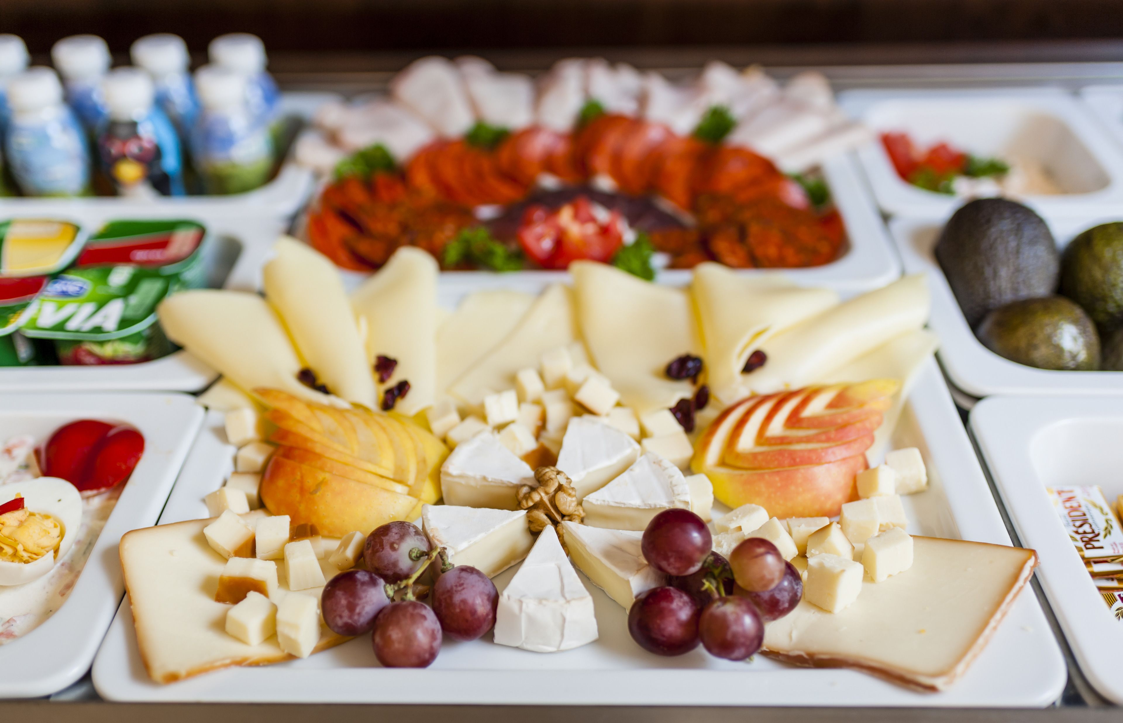 Un assortiment de fromages et de fruits présentés sur un plateau.