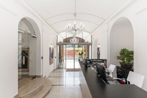 Un interior moderno con mostrador de recepción, computadora y zona de estar.