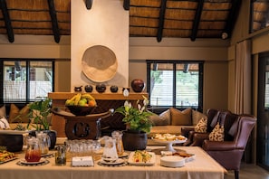 A dining area with a buffet setup, including a variety of food items and beverages. - Inyati Game Lodge (Sabi Sand Reserve)