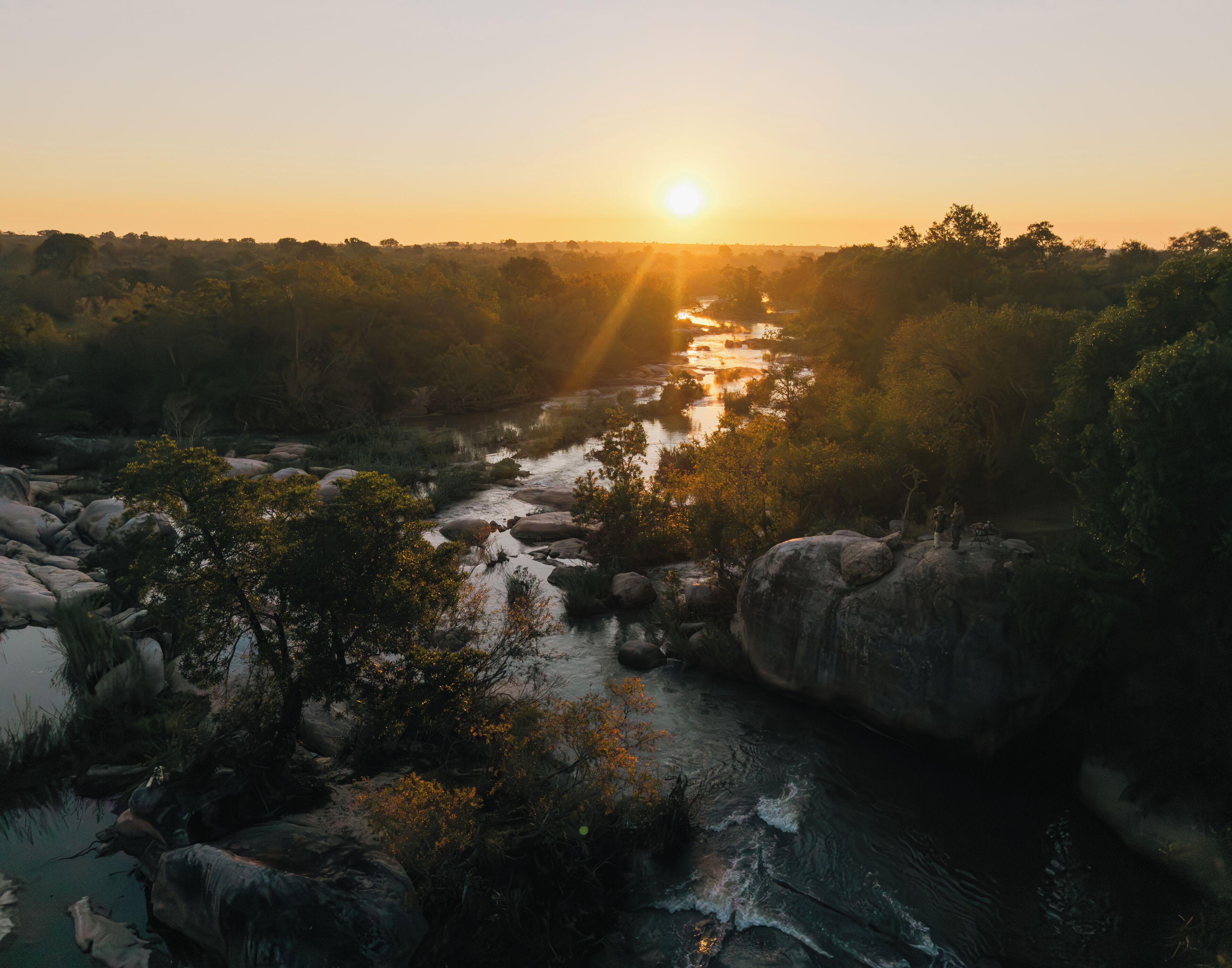 A river flowing through a rocky landscape with dense vegetation.