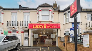 Un edificio con un cartel que dice 'Lucky 8 Hotel' y un cartel de 'Prohibido estacionar'.