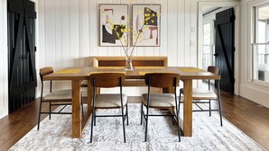 A dining area with a wooden table, chairs, a bench, and a hanging pendant light. - Hotel Cashiers (Cashiers)