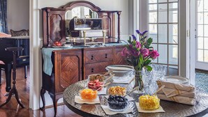 A dining table with various food items and a vase of flowers. - Stone Mountain Manor (Stone Mountain)