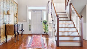 A wooden staircase with white balusters and a handrail, leading to an upper floor. - Stone Mountain Manor (Stone Mountain)