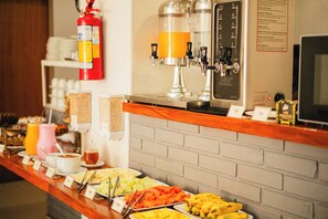 Un bufé de desayuno con diferentes alimentos y una máquina de café.