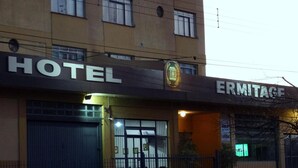 Un hotel llamado "ERMITAGE" con un cartel que indica "HOTEL" y "ENTRADA DEL HOTEL".