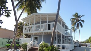 A two-story building with a balcony, surrounded by palm trees and a sandy ground. - Sands of Islamorada (Islamorada)