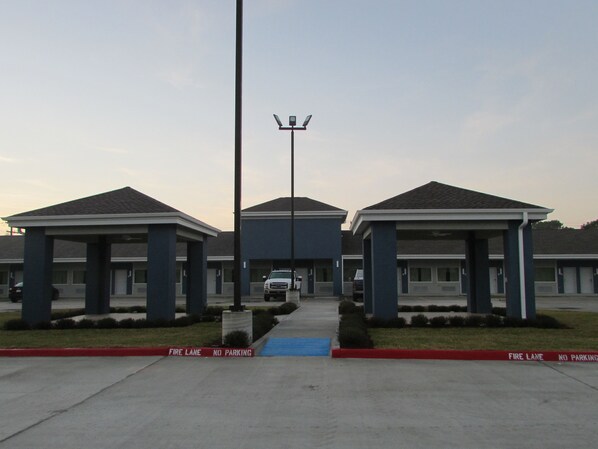 A motel with three buildings, each with a covered parking area.