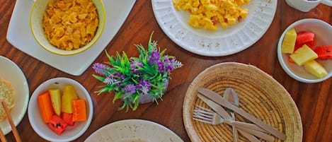 En frukostbuffé med ett varierat utbud av rätter, inklusive äggröra, flingor och frukt.