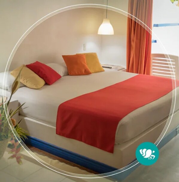 A bed with a red blanket, beige pillows, and a white headboard. - Villas Del Caribe (Cahuita)