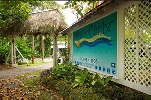 A sign for 'Houses of the Caribbean Beach Hotel' with a tropical garden setting. - Villas Del Caribe (Cahuita)