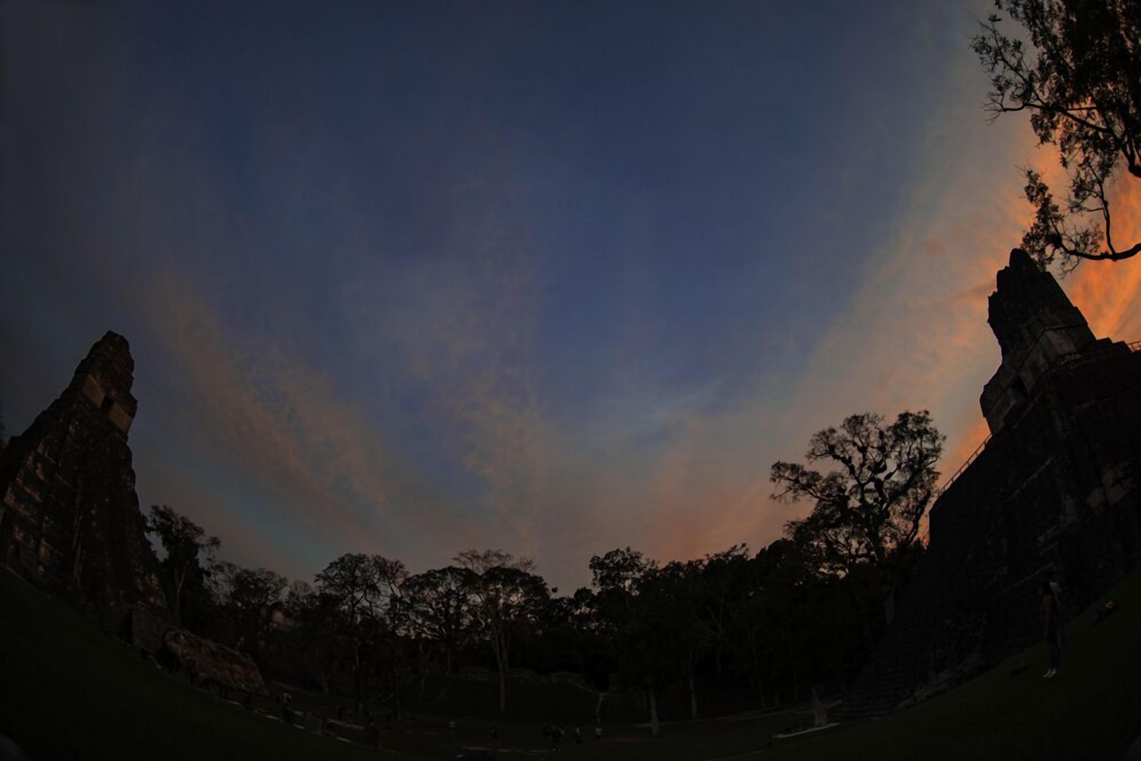 A panoramic view of a park with large rock formations and trees.