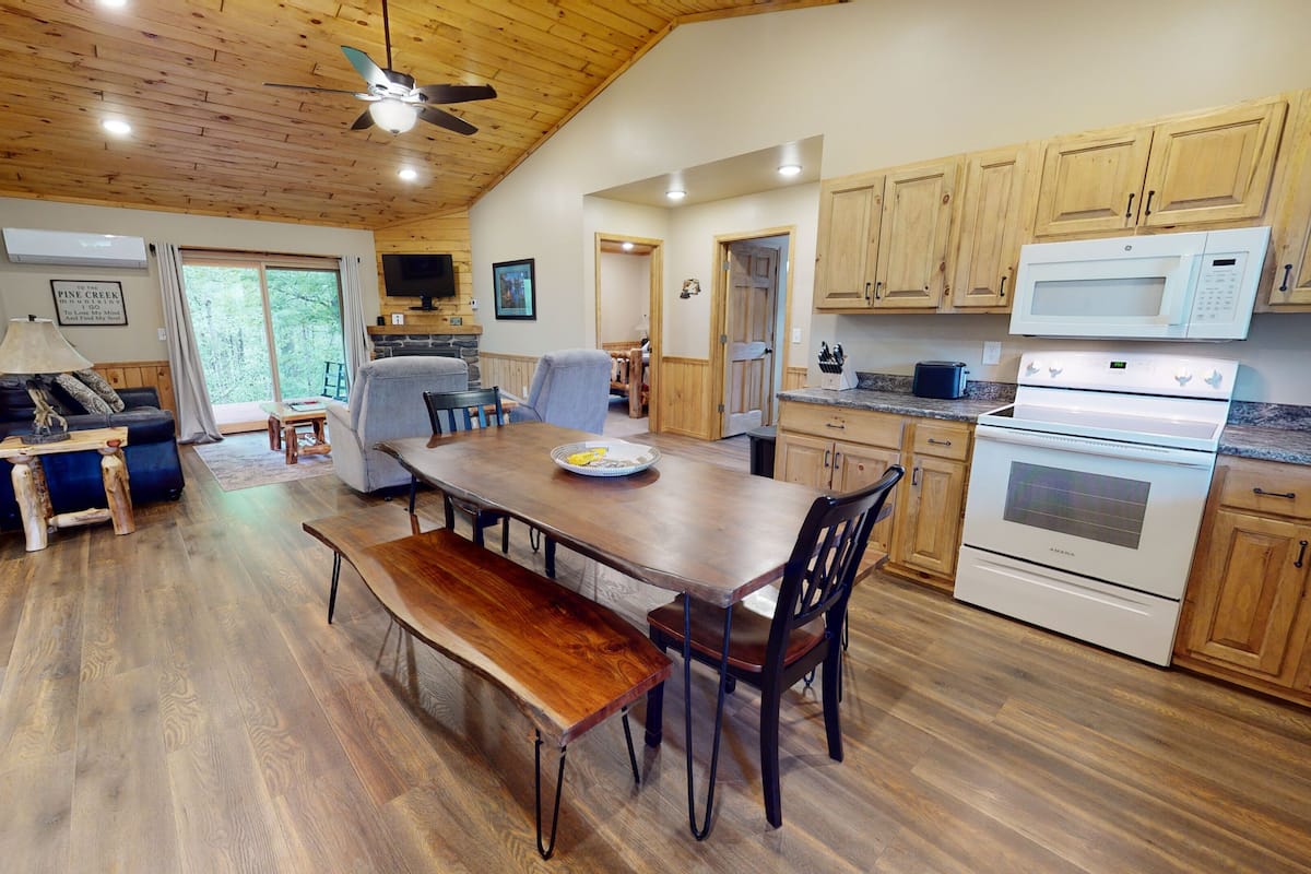 A spacious kitchen with wooden cabinets, a dining table, and a built-in oven.